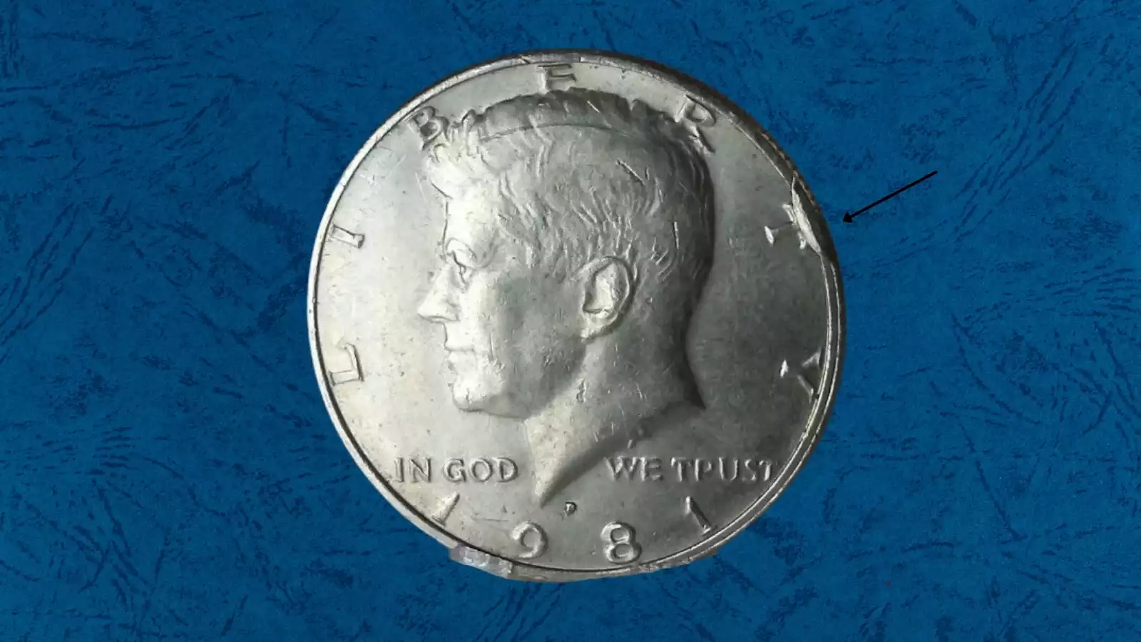 1981 Kennedy half dollar die cud error showing raised blob of metal at coin rim where die broke away
